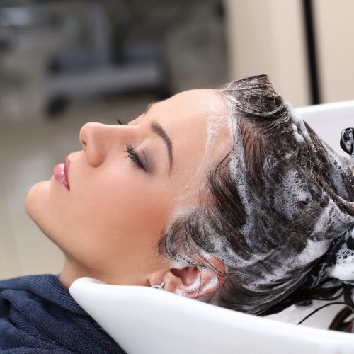 Hairdresser salon. Woman during hair wash